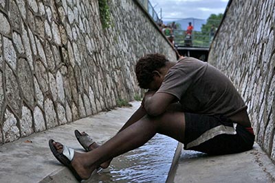 A homeless youth from the LGBT community sits in the sewer where he lives in Kingston, Jamaica. (Pic: (C) 2014 Human Rights Watch)