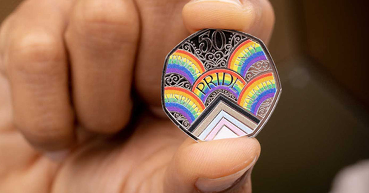 A person hold up the colourful Pride LGBTQ+ coin